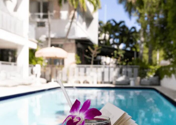 Pool with sun loungers and a pink parasol